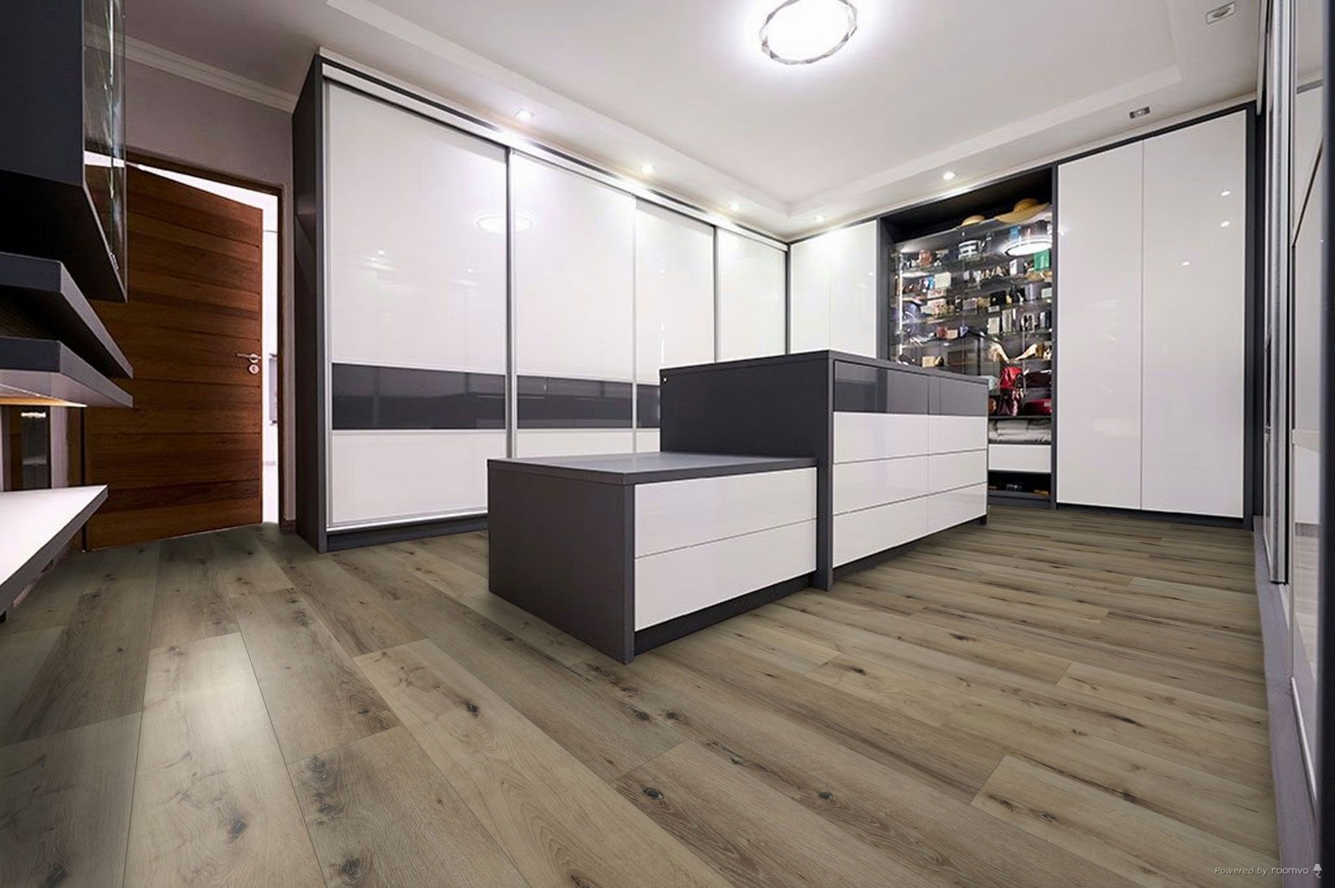 A walk in closet with hardwood floors and white cabinets