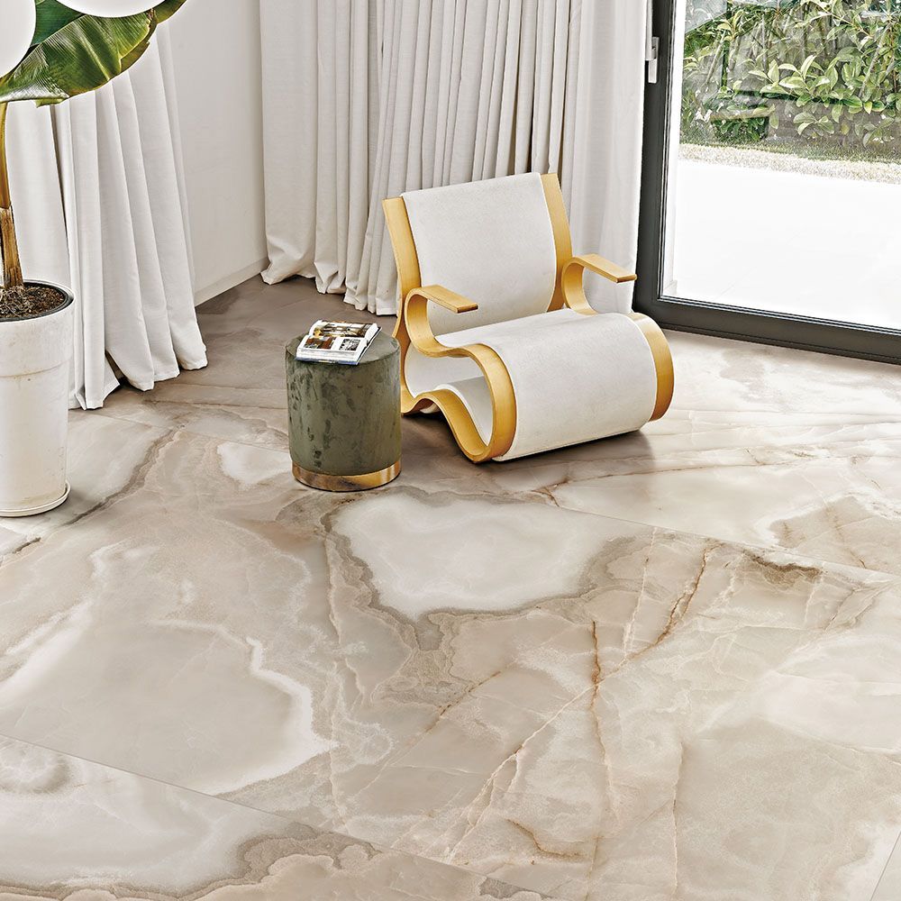 A chair is sitting on a tiled floor in a living room next to a plant.