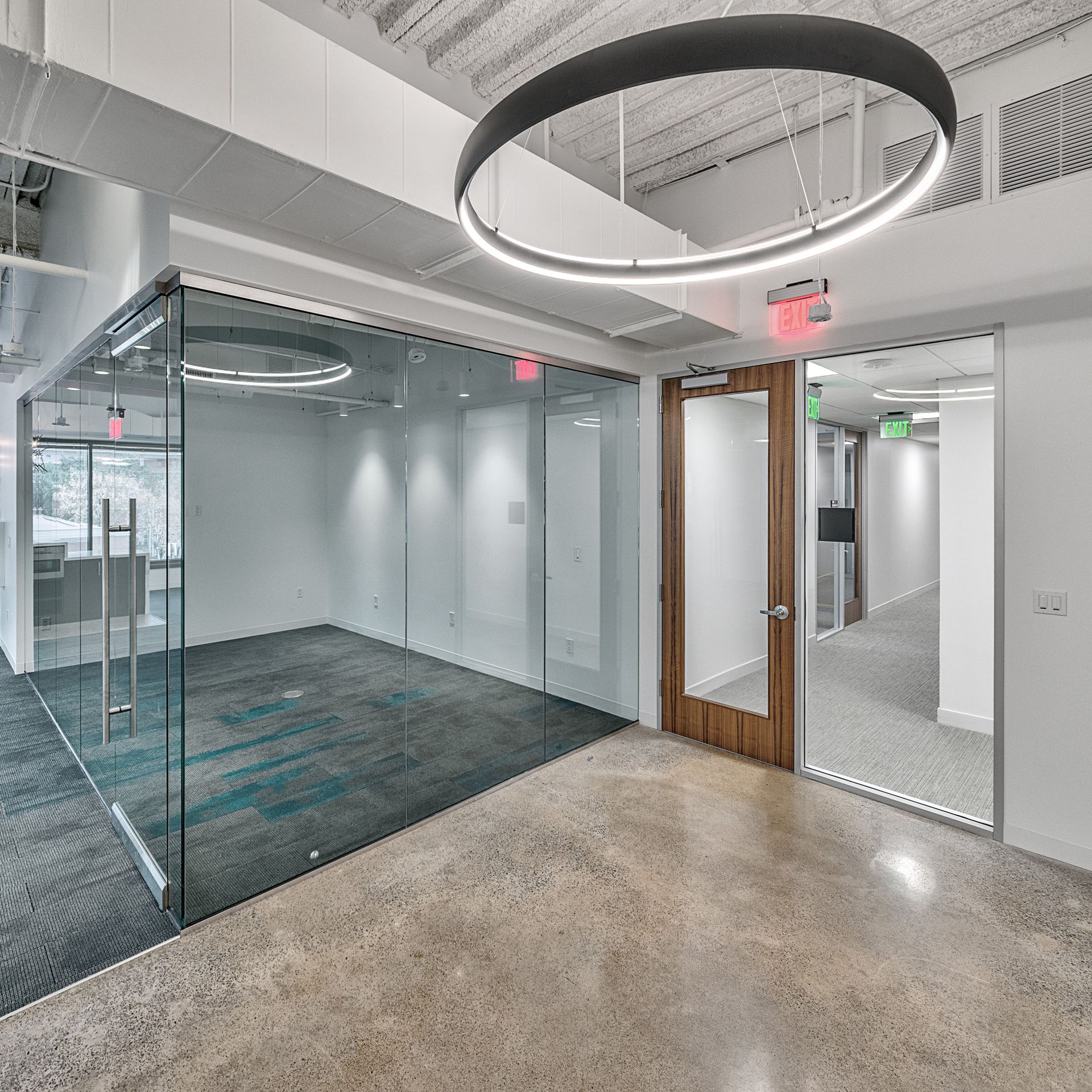 Modern office space with glass walls and a circular light fixture