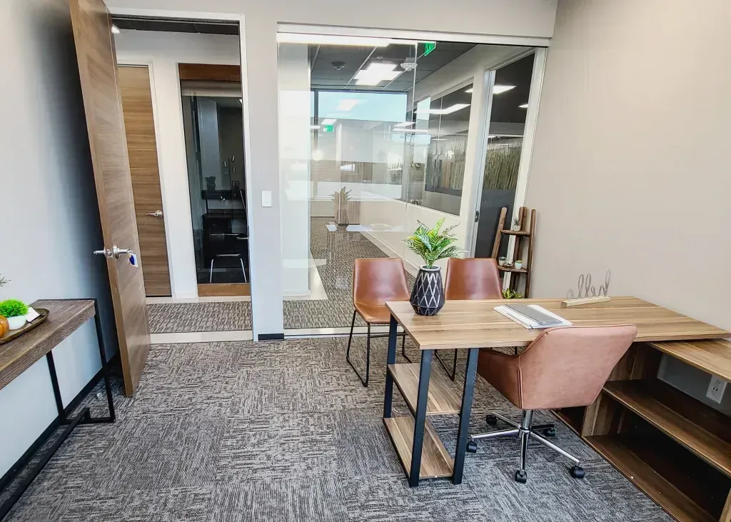 A small office with a wooden desk and chairs.