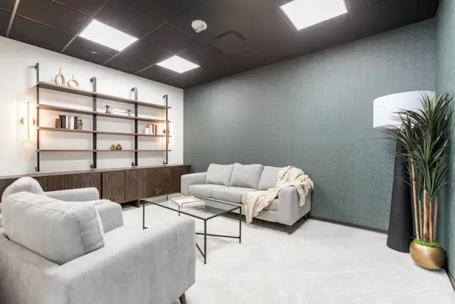 A living room with a couch, chairs, and a coffee table.