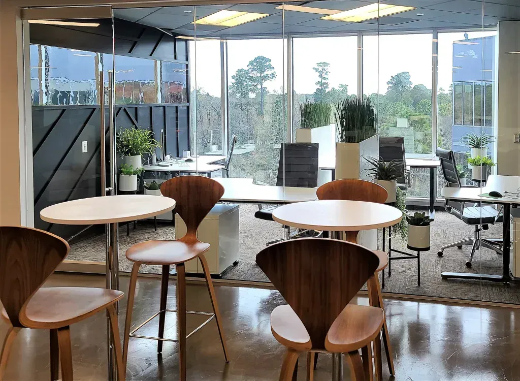 A room with tables and chairs in it and a lot of windows.