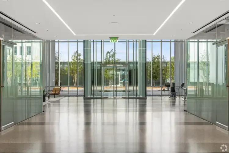 A large empty lobby in a building with lots of windows.