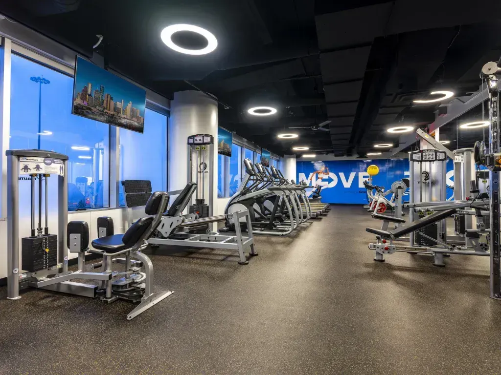 A large gym filled with lots of exercise equipment.