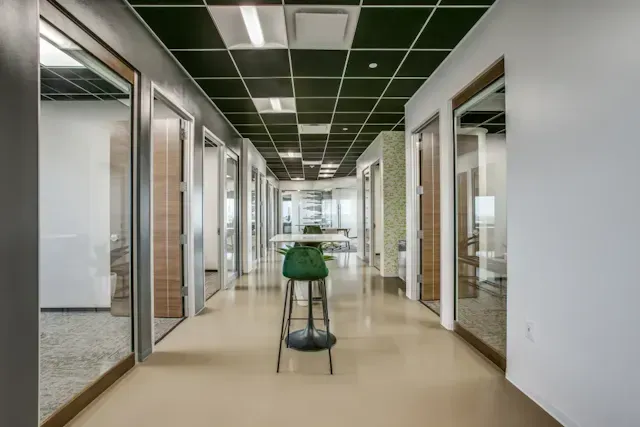 A long hallway with a table and chairs in the middle.