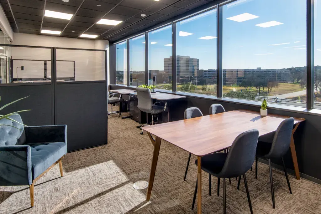 There is a table and chairs in the middle of the room.