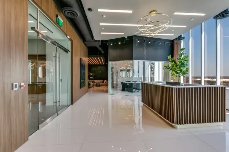 A large lobby with a reception desk and a lot of windows.