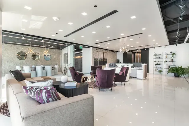 A living room with a couch, chairs, tables, and a chandelier.