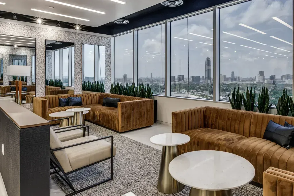 A living room filled with furniture and tables with a view of the city.