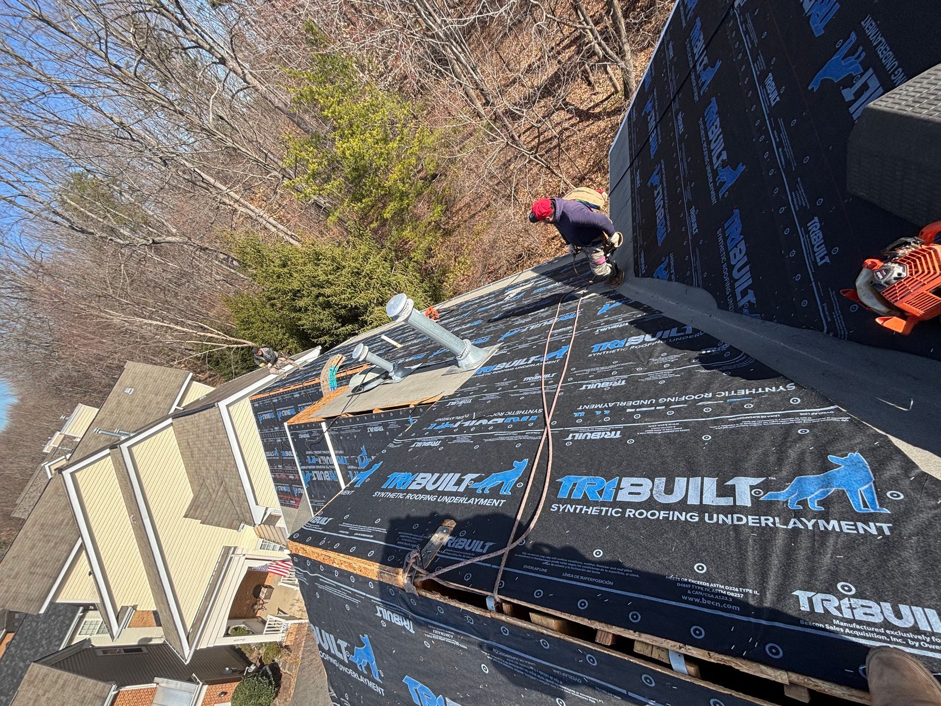 A man is working on the roof of a house.