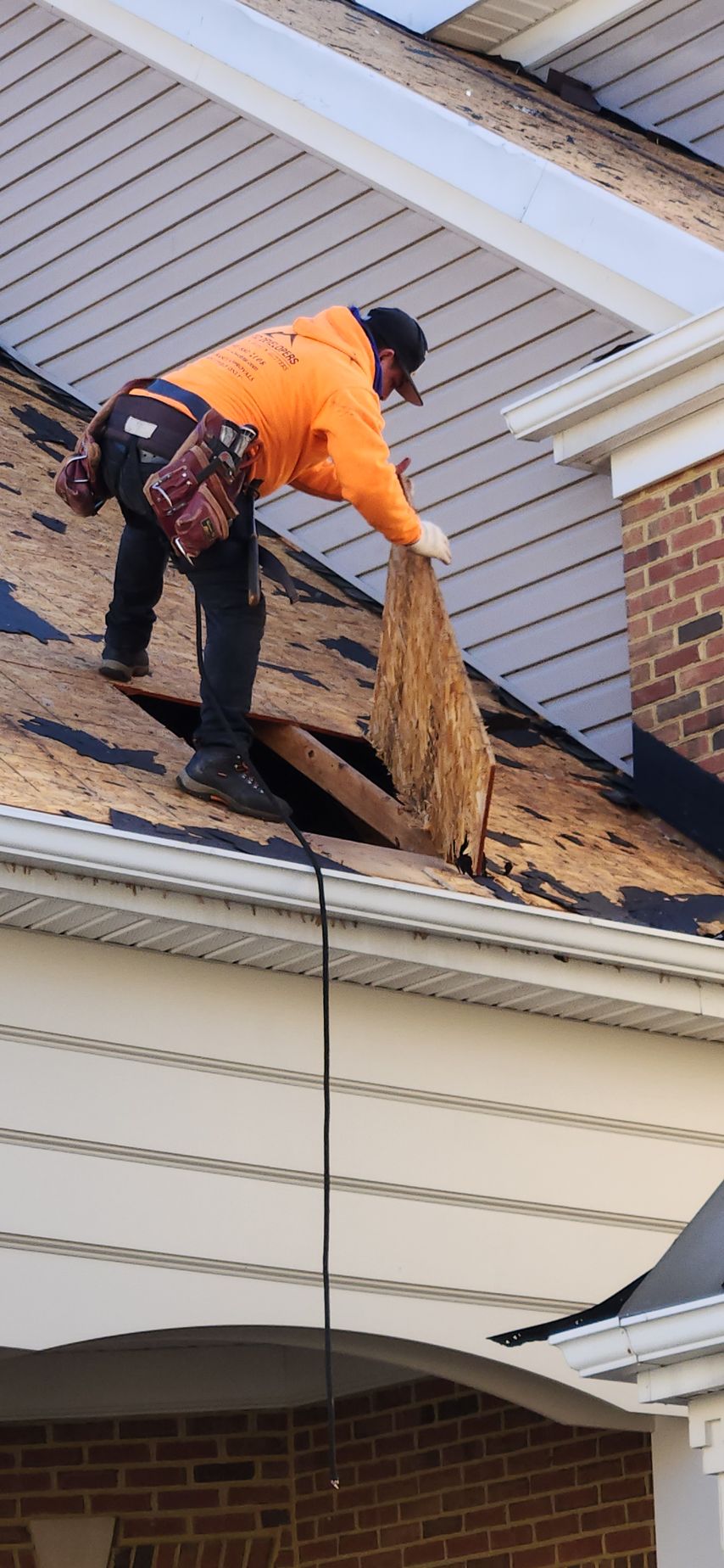A man is working on the roof of a house.