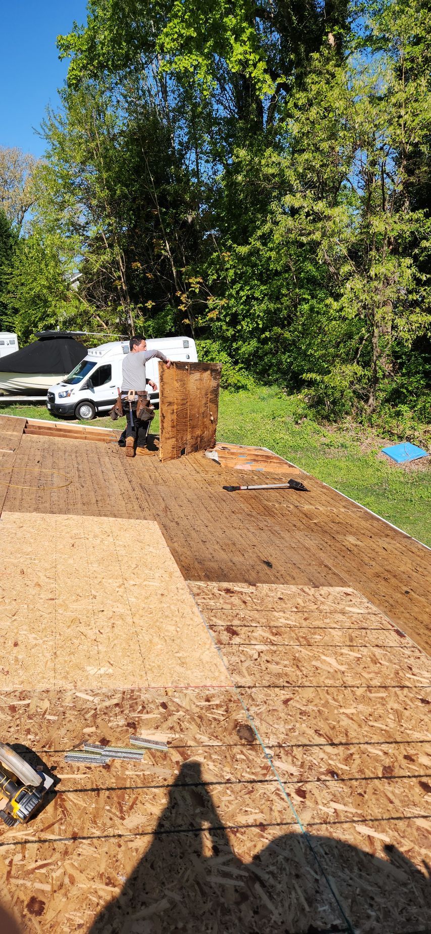A group of people are working on a roof in a yard.