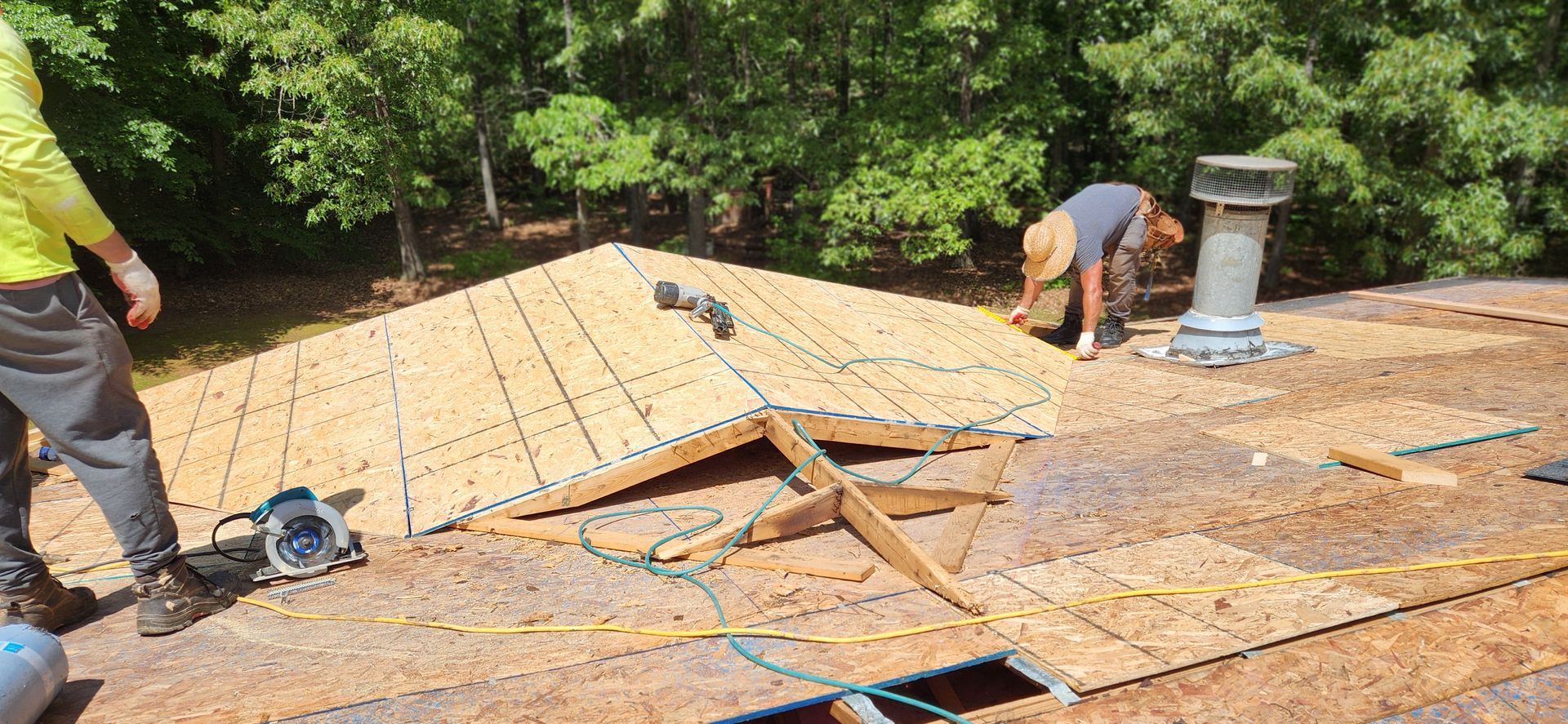 Two men are working on the roof of a house.