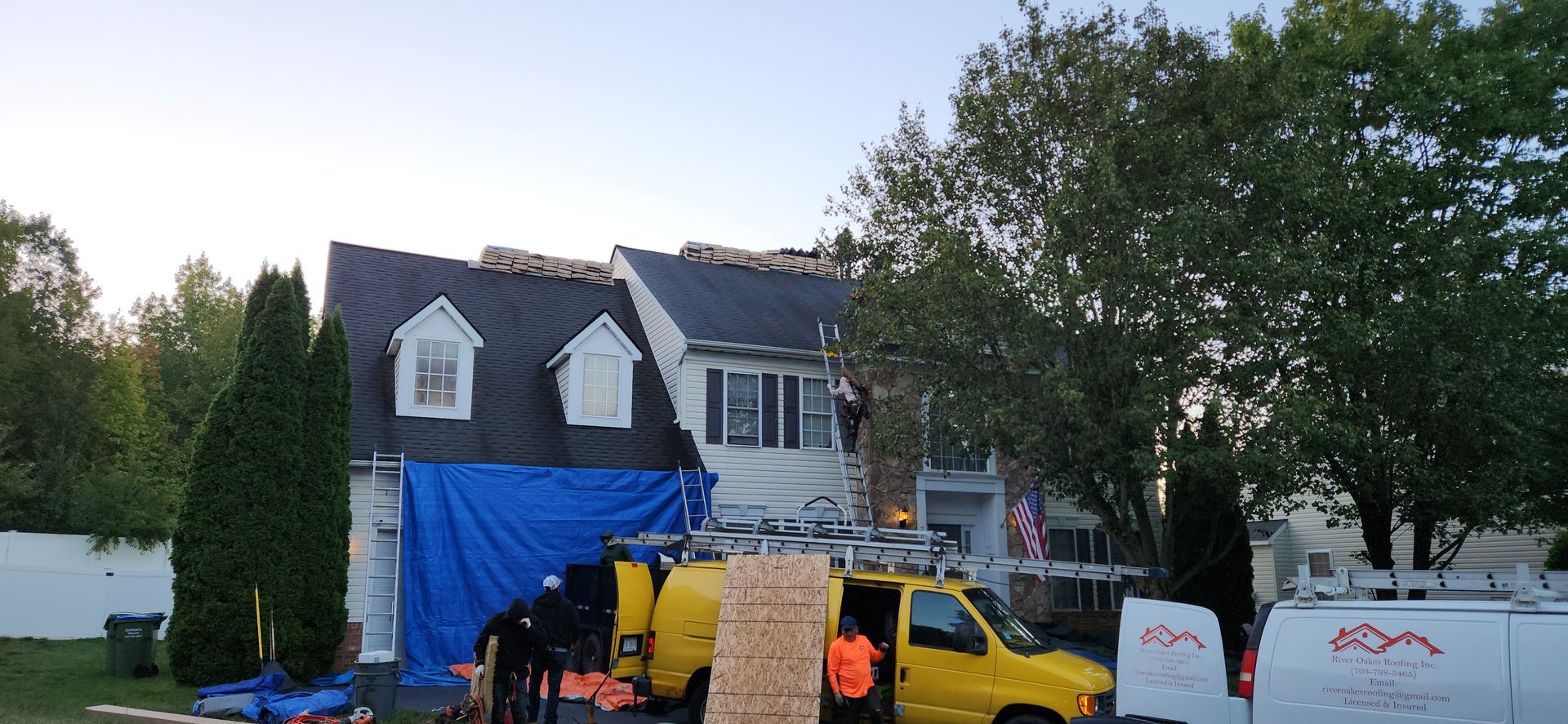 A yellow truck is parked in front of a house.