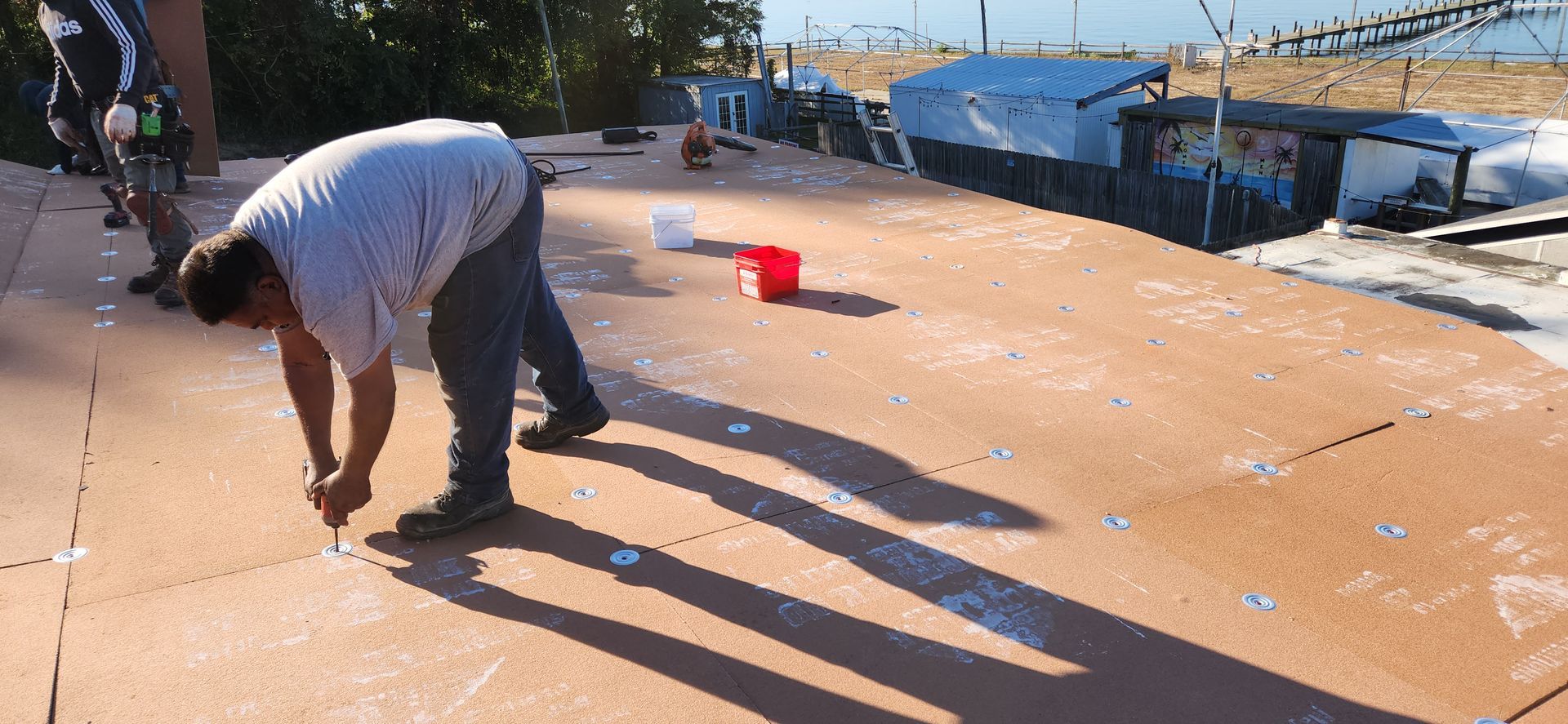 A man is bending over to paint a concrete surface