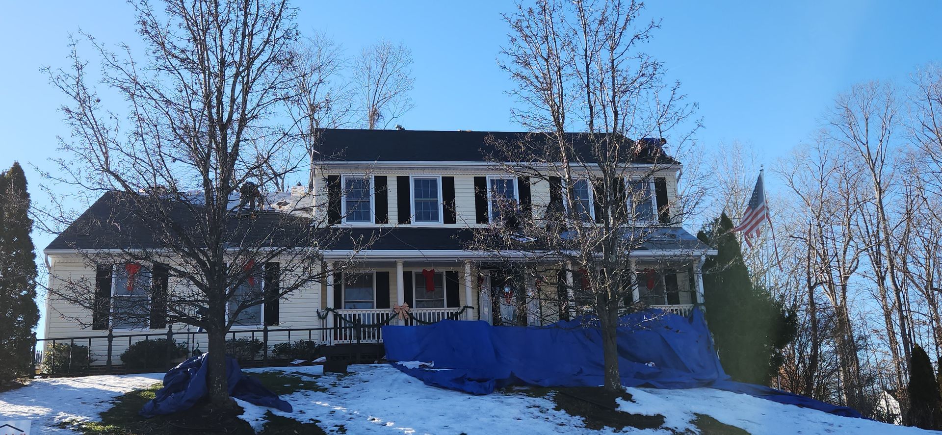 A large house is sitting on top of a snow covered hill.