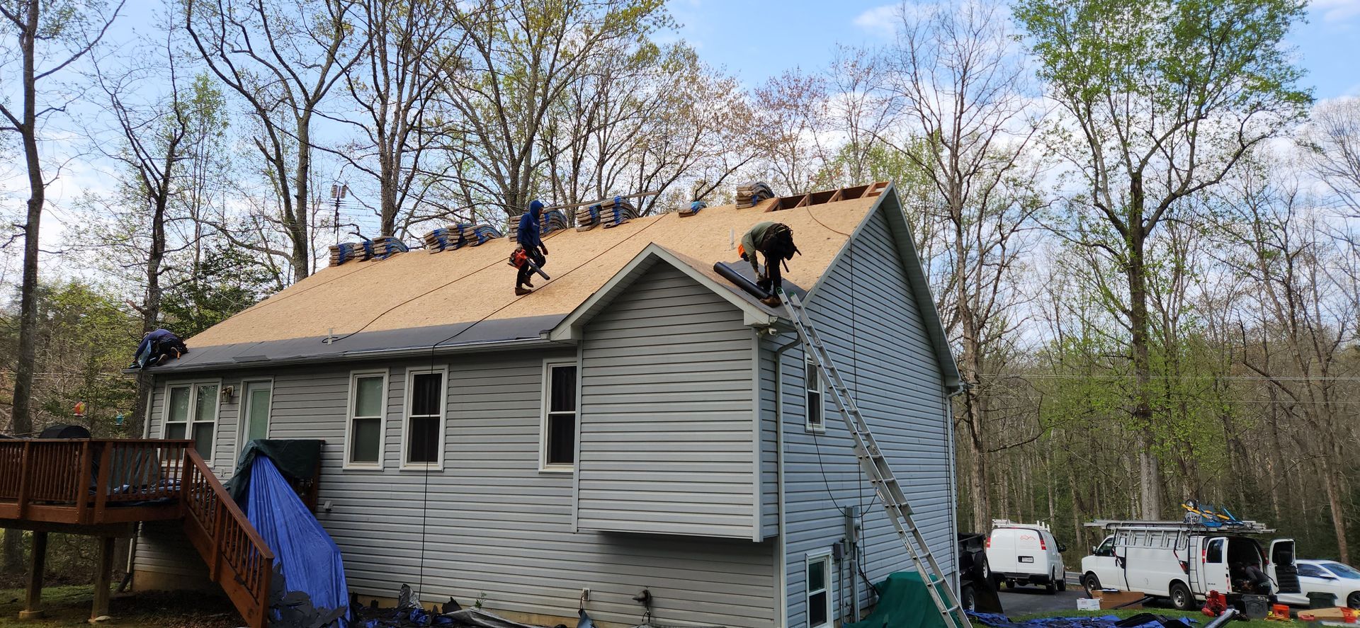 A group of people are working on the roof of a house.