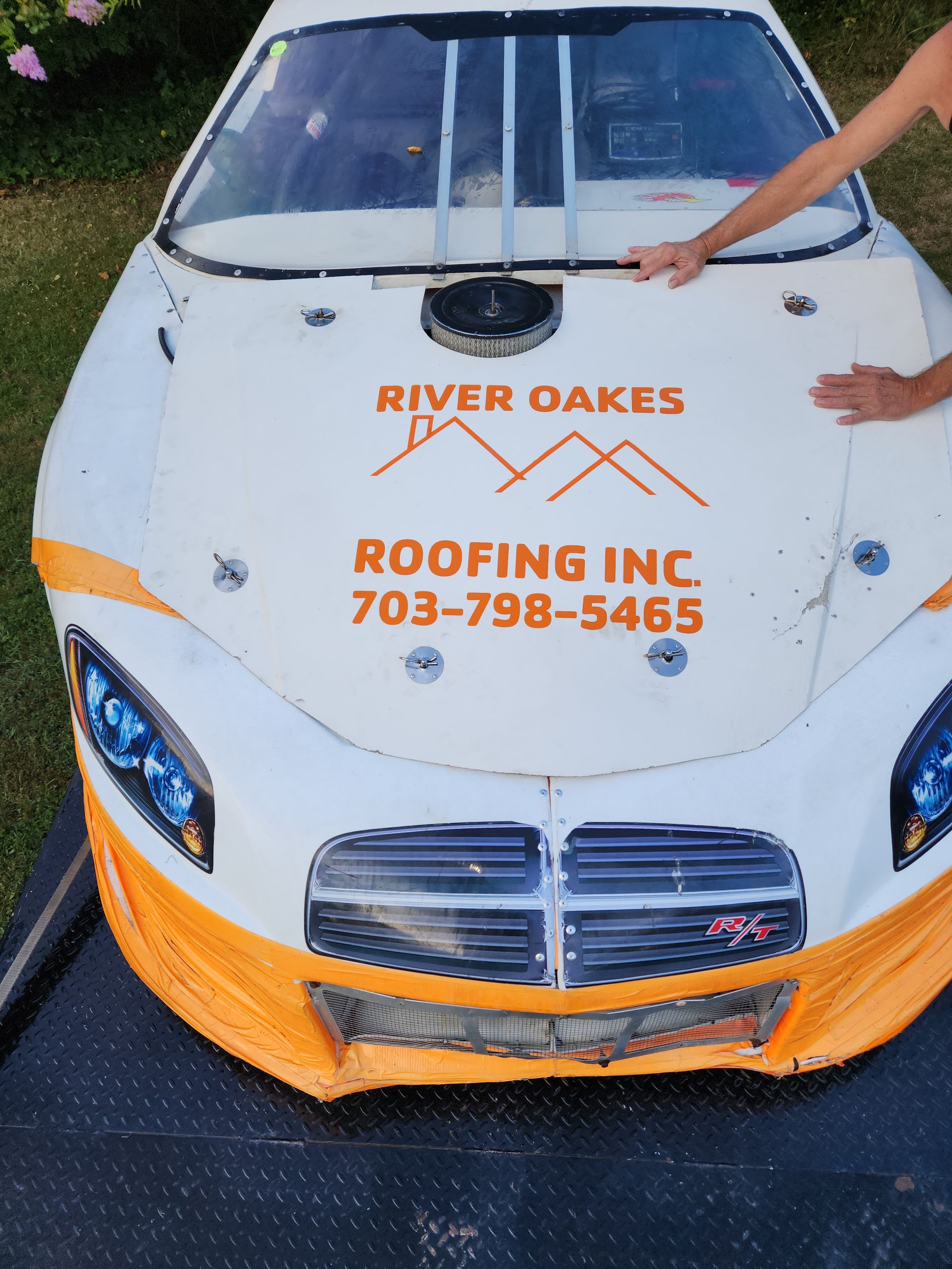 A race car with river oaks roofing inc. written on it