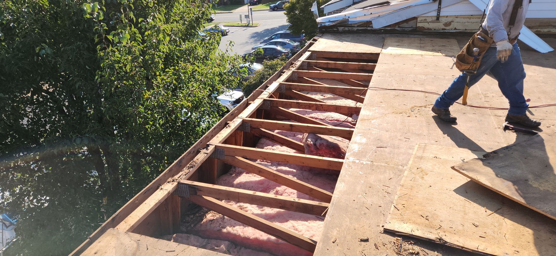 A man is standing on top of a wooden roof.