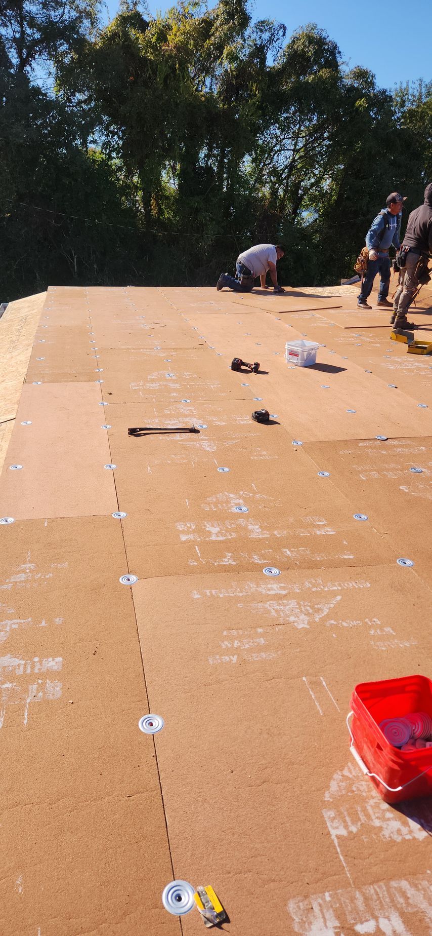 A group of people are working on a wooden roof.
