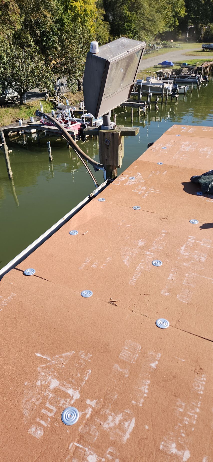A boat is docked at a dock next to a body of water.