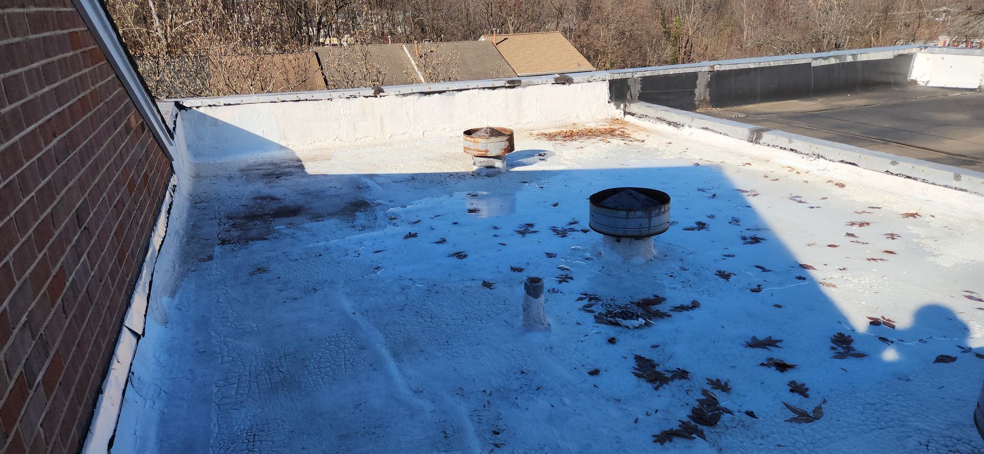 A roof with a chimney on it and a lot of leaves on it.