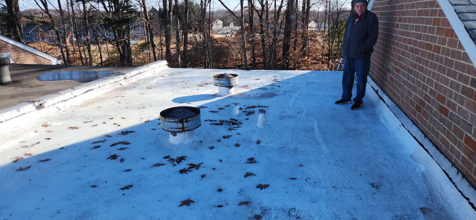 A man is standing on the roof of a building.