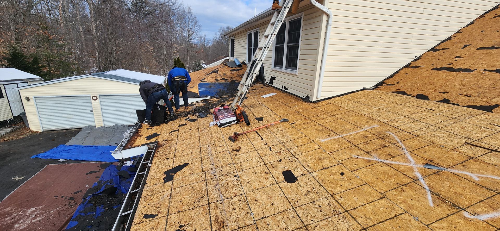 A group of people are working on the roof of a house.