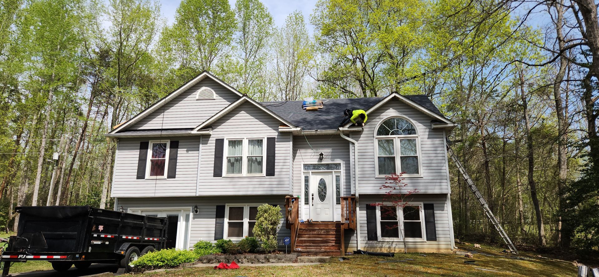A large white house with a black truck parked in front of it.