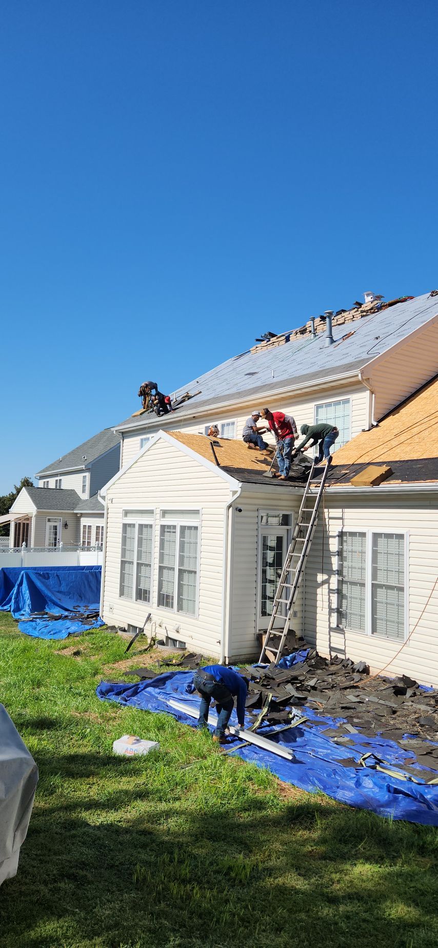 A group of men are working on the roof of a house.
