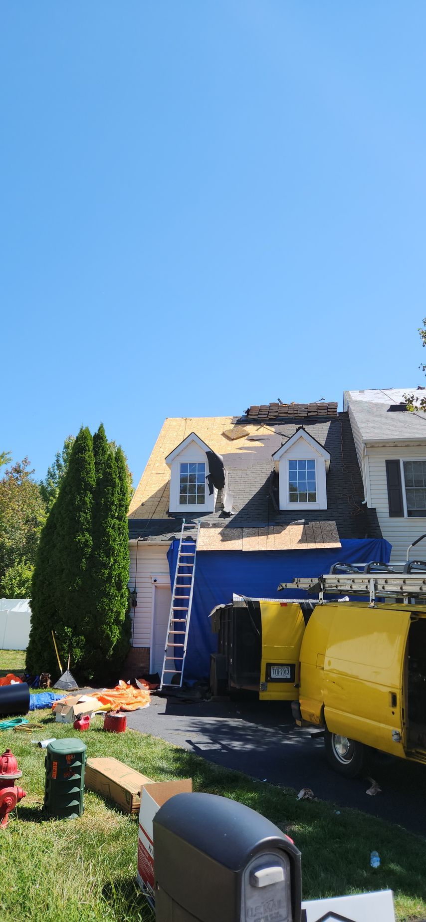 A yellow van is parked in front of a house under construction.