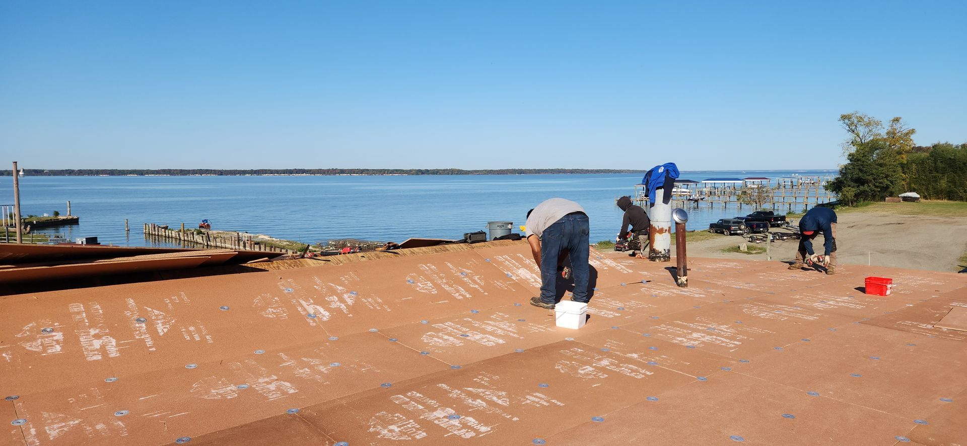 A group of people are working on a beach near the water