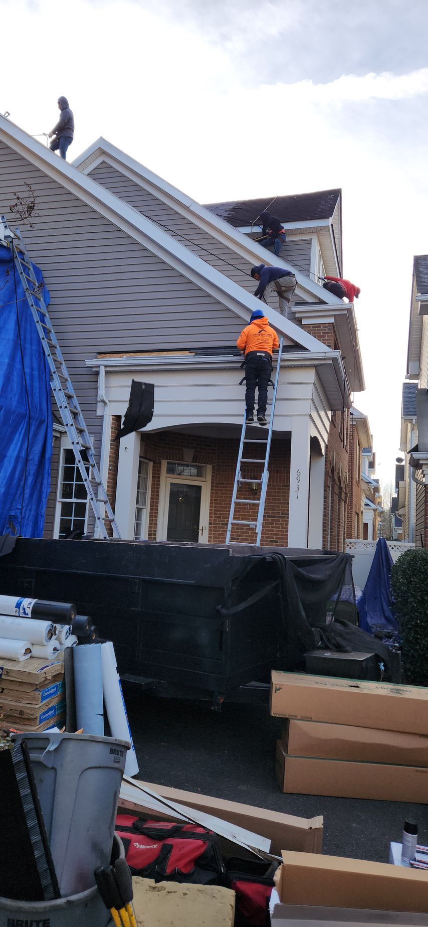 A group of people are working on the roof of a house.