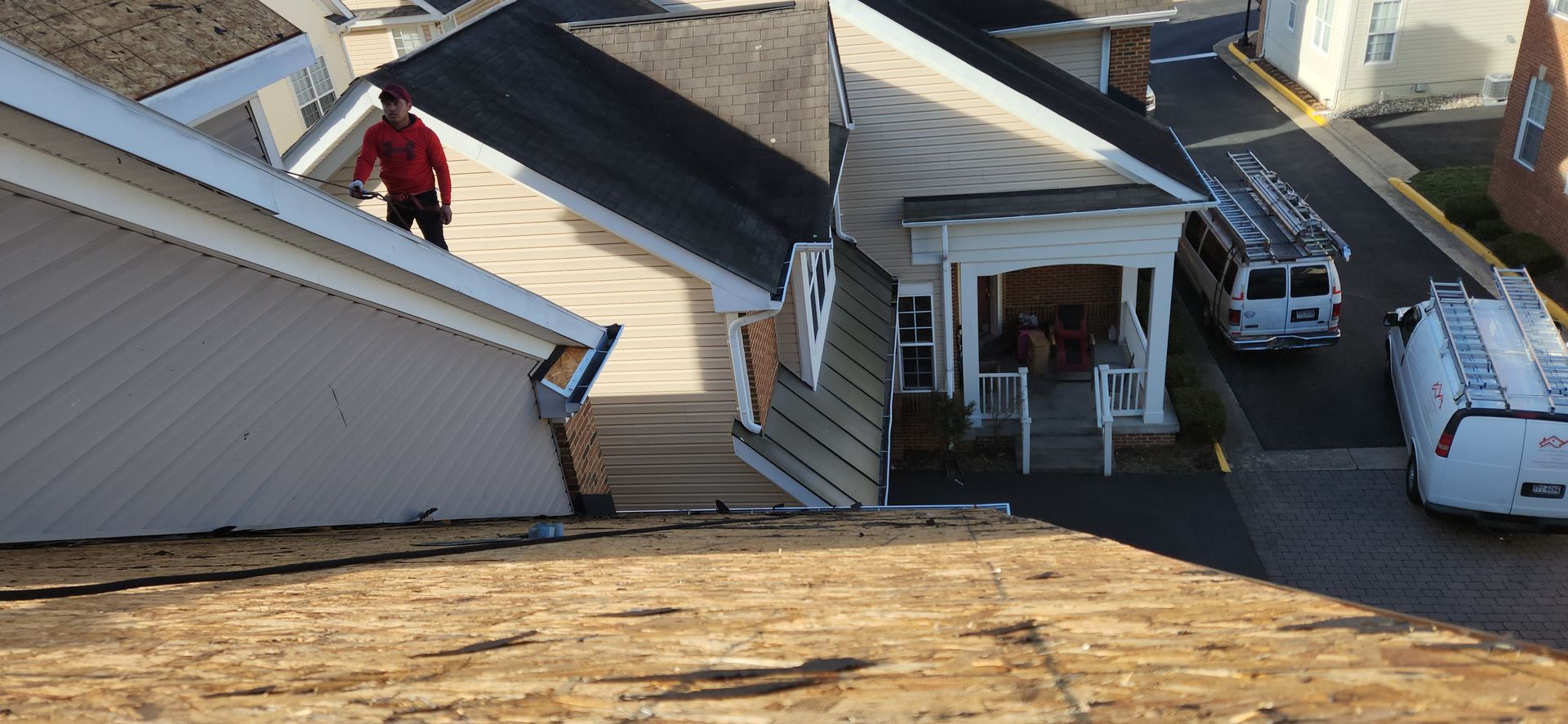 A man is standing on the roof of a house.