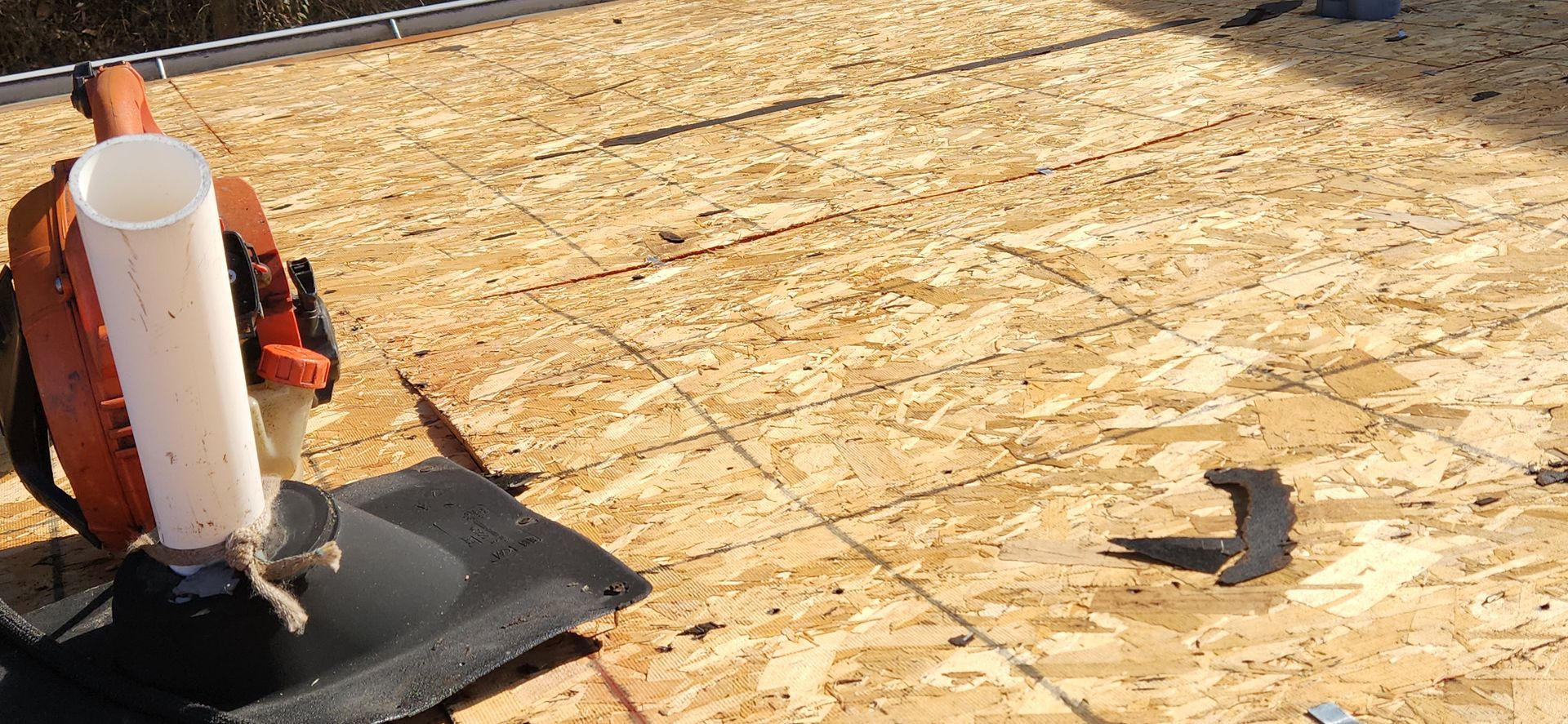 A lawn mower is sitting on top of a wooden roof.