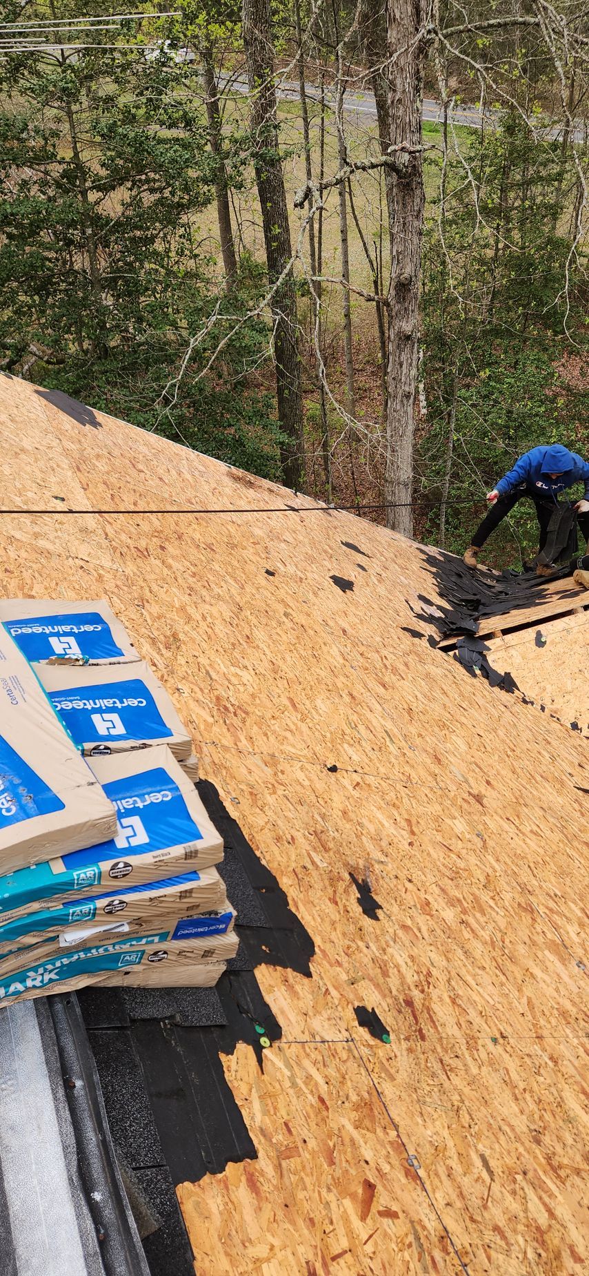 A man is working on the roof of a house.