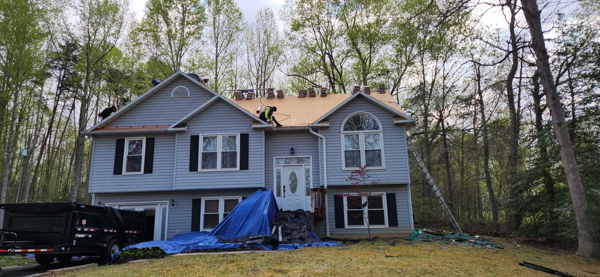 A large house is being remodeled with a roof being installed.