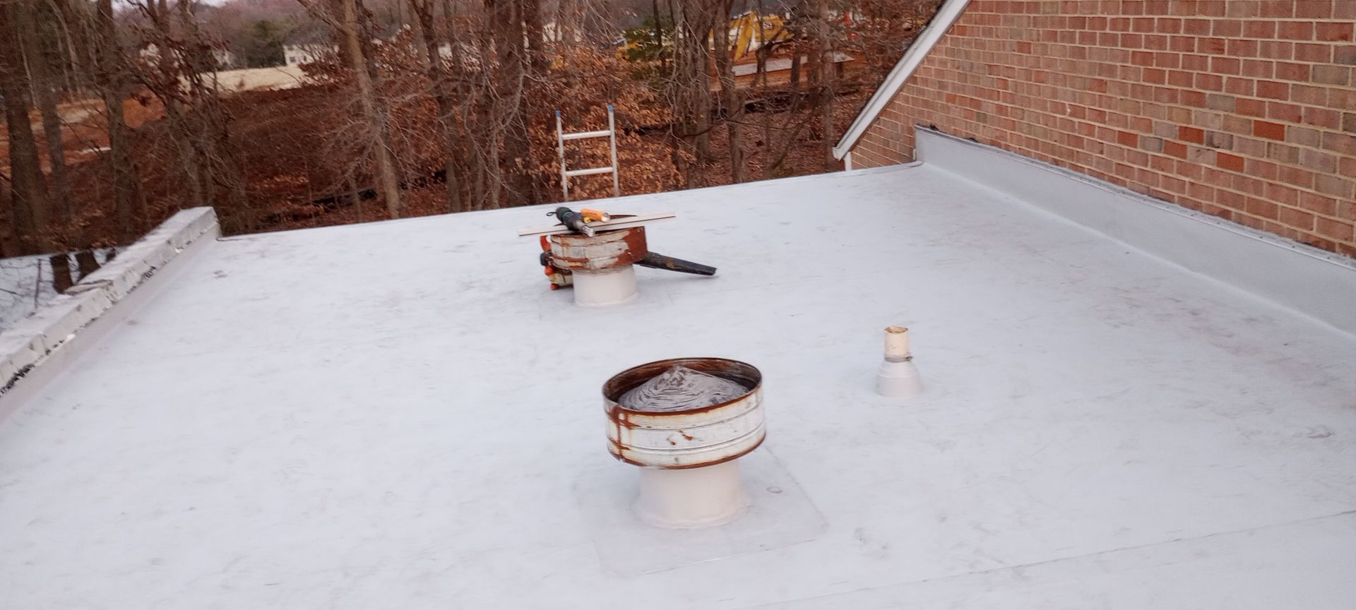 There are two chimneys on the roof of a building.