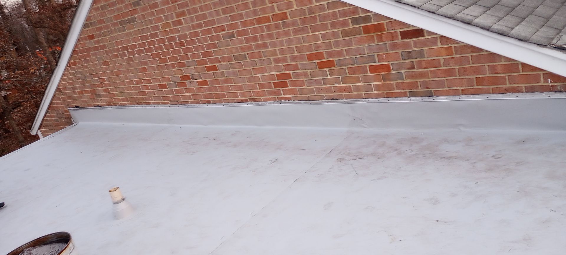 A white roof is sitting on top of a brick building.