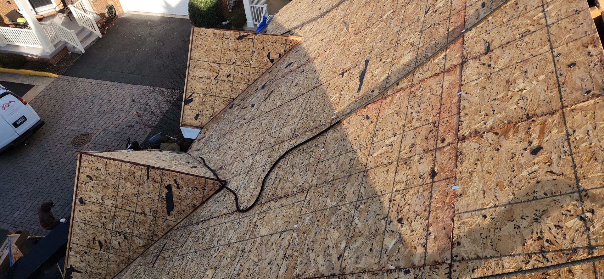 A roof is being built with plywood and a ladder.