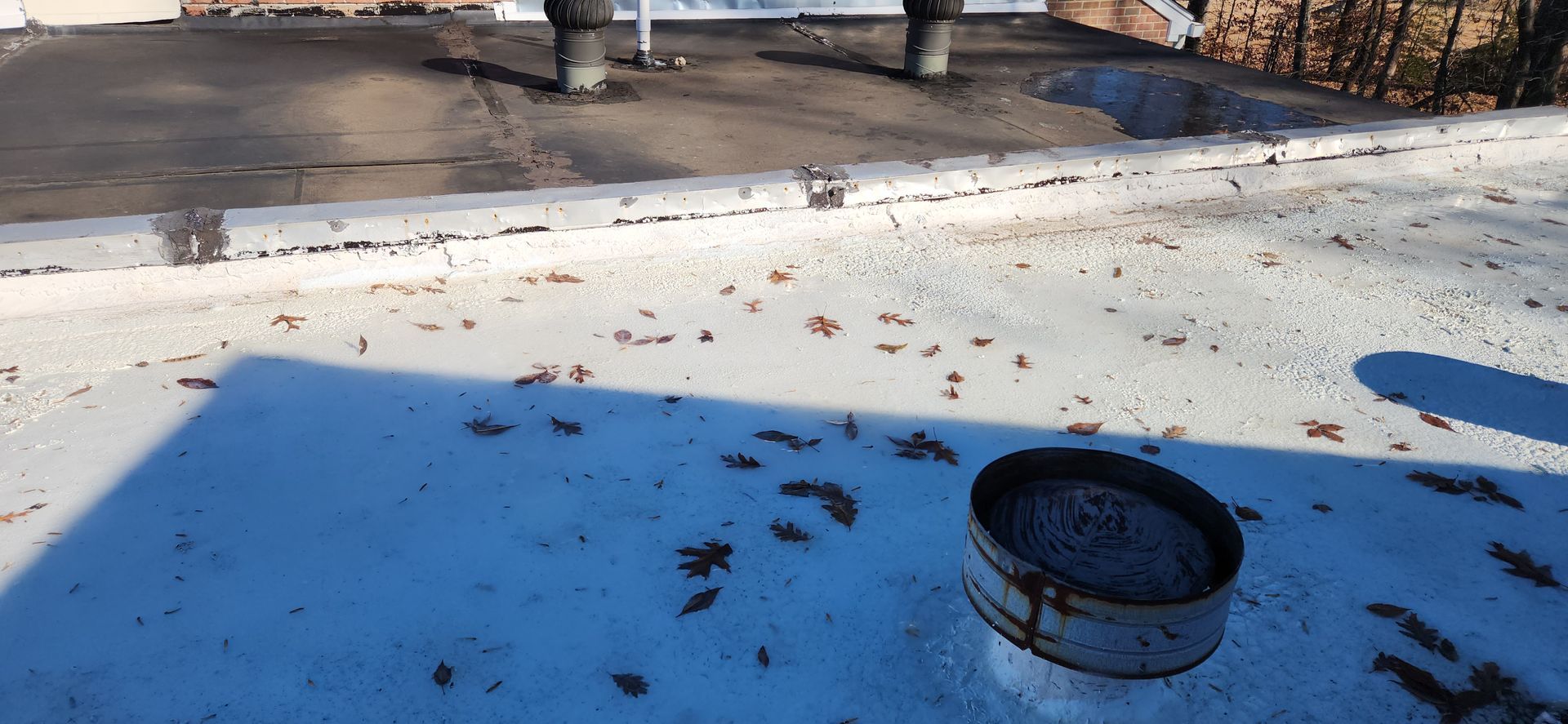 A roof with a chimney on it and leaves on it.