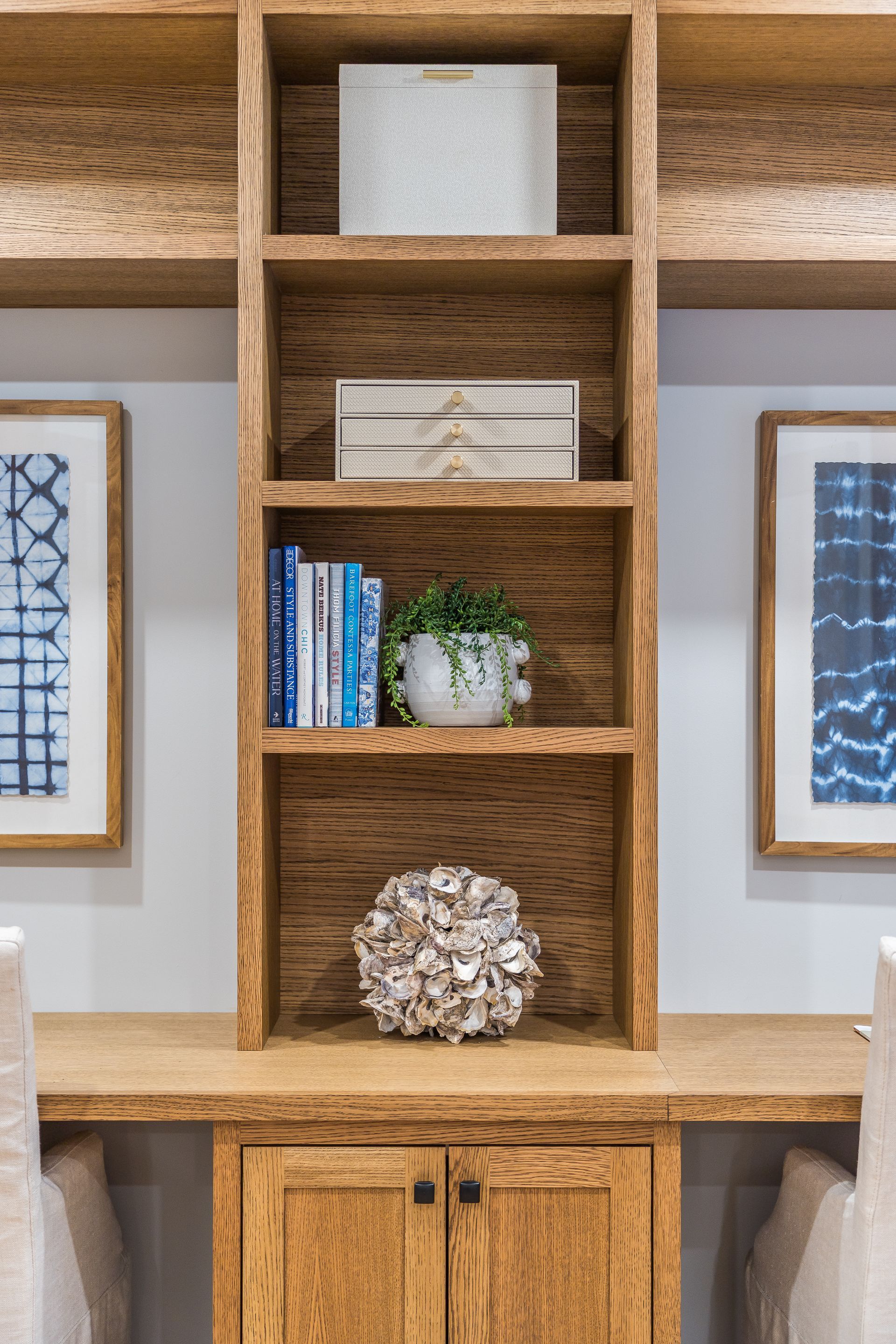 Wooden shelving unit with books, plant, and decorative objects.