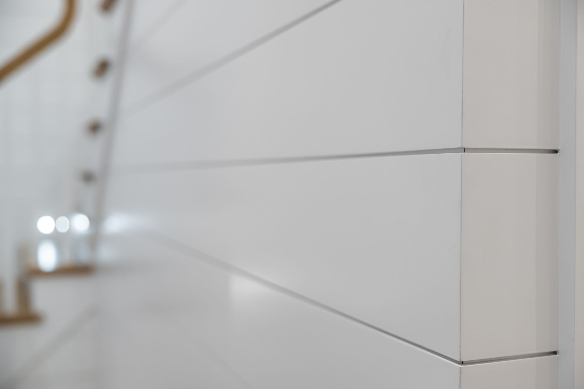 White wall with horizontal lines, a corner, and a blurred background with wooden railing.