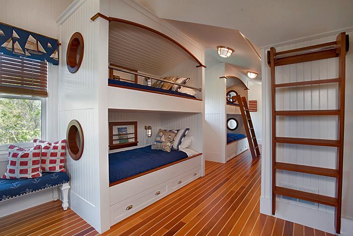 Nautical-themed bedroom with wooden bunk beds, built-in storage, and hardwood floors resembling a ship deck.