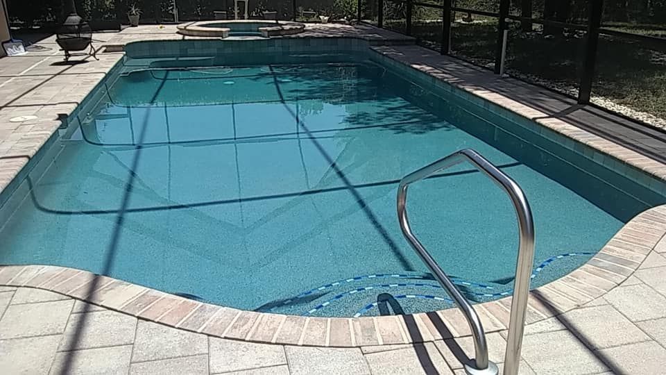 Swimming pool with blue water and brick coping.