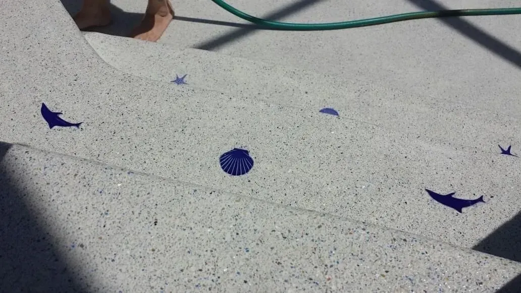 Scattered blue paint splotches and dolphin shapes on a textured, light-colored surface.