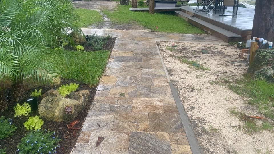 Stone pathway in a landscaped yard, with a grassy area and deck visible.