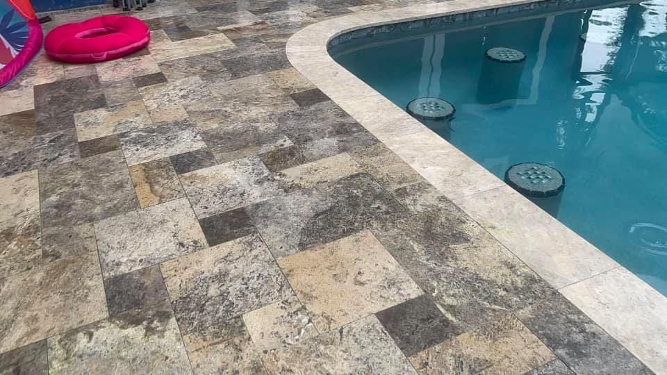Pool with stone tile deck and pink float.