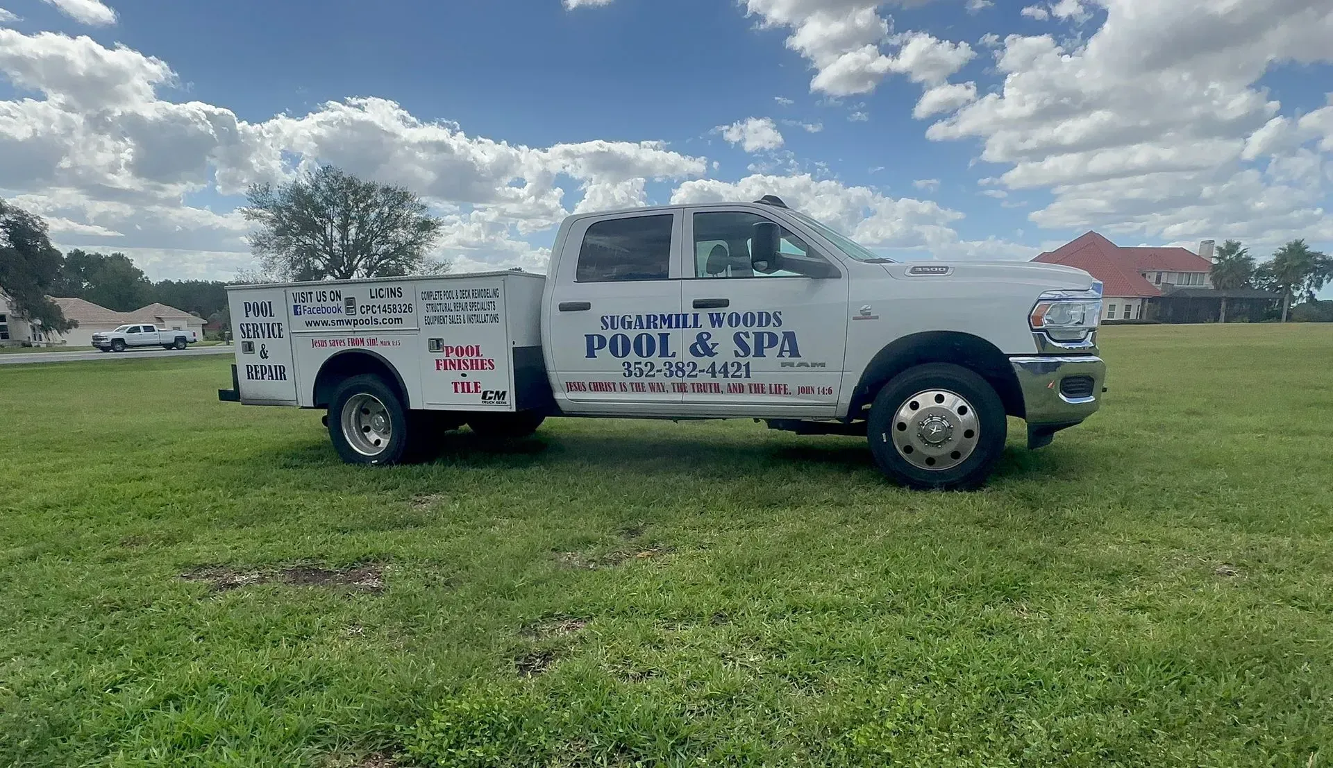 A white utility truck for Clearwater Pool & Spa parked in a grassy field under a cloudy sky.