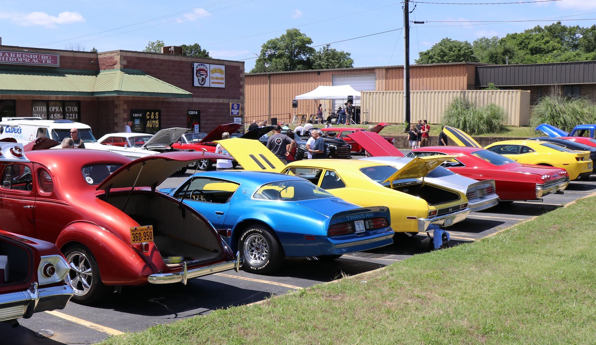 Row of brightly colored vintage cars parked outside a building on a sunny day